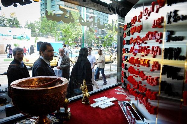 People can be seen looking at exchange rates in the currency exchange store in Ferdowsi Sq. in Tehran.